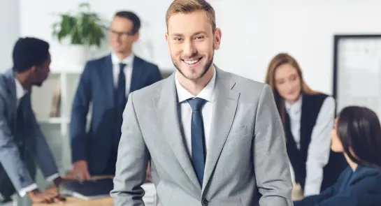 handsome-young-manager-looking-at-camera-with-blur-2022-12-16-17-02-35-utc-scaled