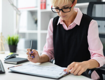 Kobieta przy biurku wypełniająca wniosek