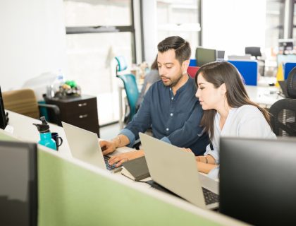 manager i managerka pochyleni nad laptopem
